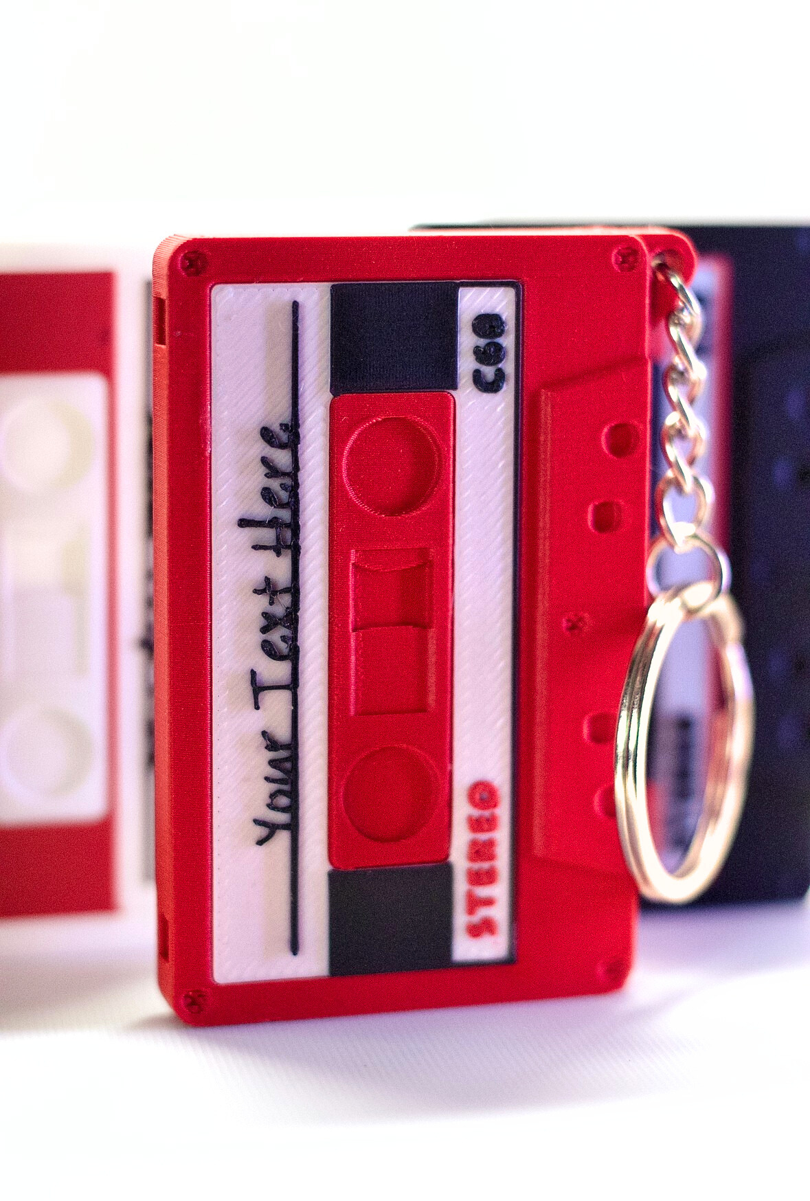 Red cassette tape keychain with a keyring on a white background